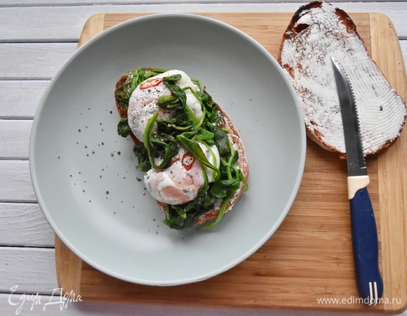 Смазала ломтики поджаренного хлеба творожным сыром, сверху уложила шпинат и яйца.