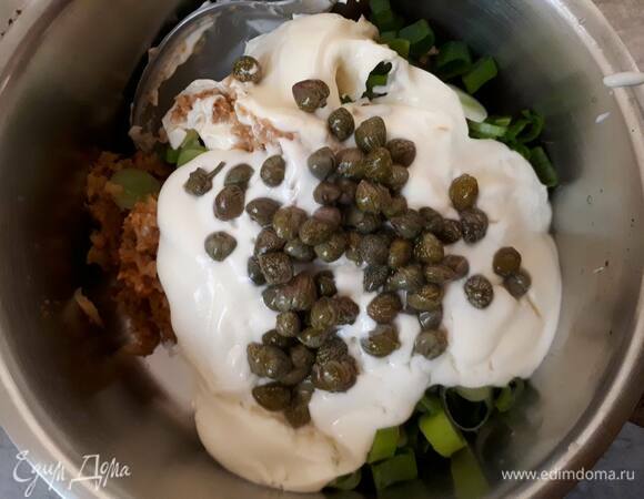 Выложите получившуюся пасту в кастрюльку, добавьте сливки, мелко нарезанный зеленый лук и каперсы. Перемешайте, доведите до кипения и проварите на медленном огне 5 минут.