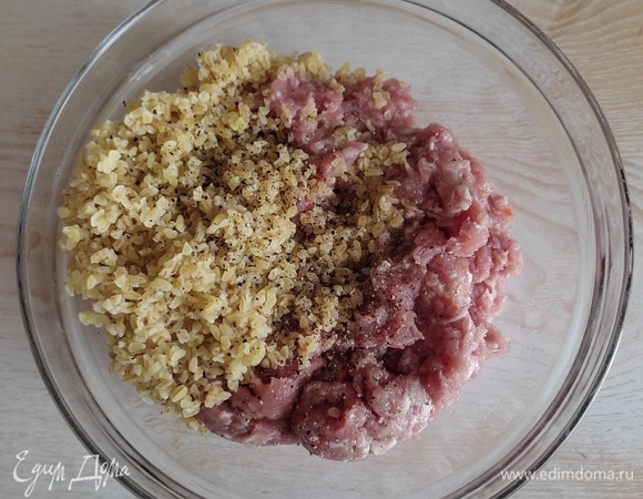 В фарш добавить соль, черный молотый перец, булгур. Хорошо перемешать.