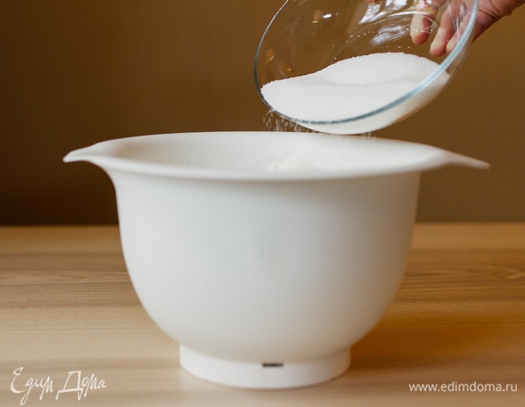 Не прекращая взбивания, всыпать частями сахар, взбить до устойчивых пиков.