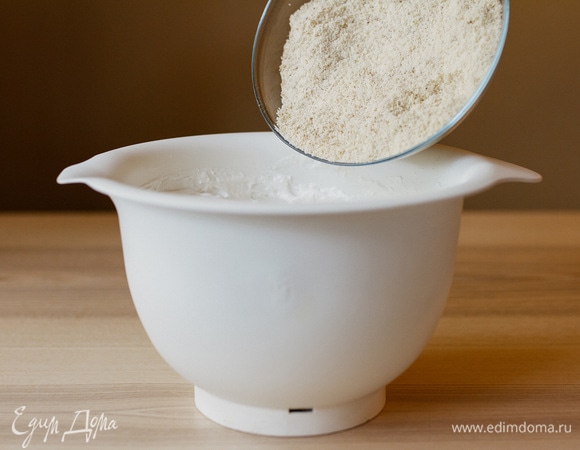 Всыпать к белкам просеянную миндальную муку, аккуратно перемешать лопаткой.