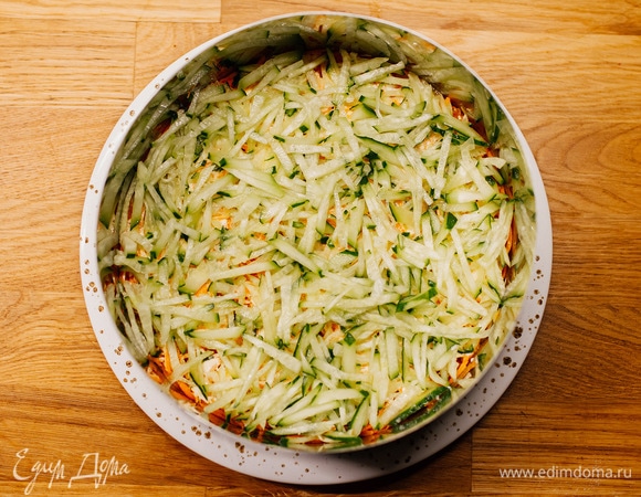 Затем выложить слой из натертых на крупной терке огурцов.