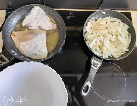 В пакет всыпать муку, перец, соль. Поместить рыбу и перемешать. Далее выложить рыбу на разогретую сковороду. На другой сковороде жарить лук.