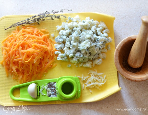 Сыр (у меня чеддер, но можно использовать любой другой полутвердый сыр) натрите на крупной терке, чеснок измельчите, голубой сыр раскрошите. Перец измельчите.