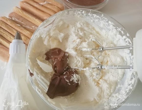 2–3 ложки сливочного крема отложить. В остальной добавить шоколадную пасту и взбить крем еще раз.