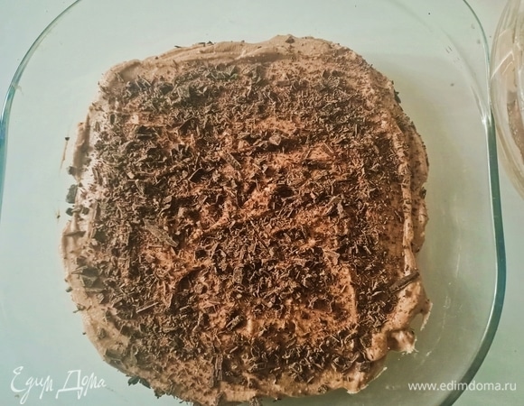 Крем посыпаем шоколадной крошкой. Затем укладываем слой печенья, окунув его в шоколадное молоко. Откладываем пару ложек крема для украшения, остальным покрываем печенье и выравниваем поверхность.
