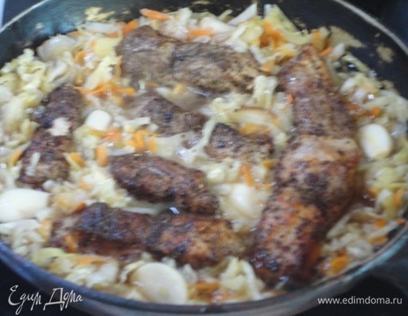 Разогреть духовку до 150°C. Выложить к капусте ребрышки, разложить дольки чеснока и влить яблочный сок. Довести до кипения на высоком огне, убавить нагрев и тушить 20 минут.