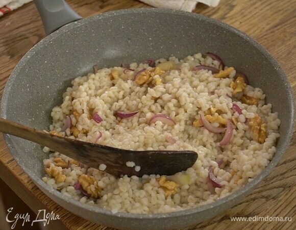 Грецкие орехи порезать на четвертинки, выложить к луку с чесноком, перемешать и снять с огня, добавить готовую перловку и все еще раз перемешать.