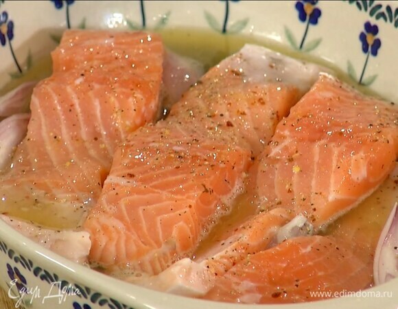 В жаропрочную керамическую форму поместить нарезанный шалот и каперсы, сверху выложить семгу, посолить, поперчить, полить апельсиновым соком и оливковым маслом.