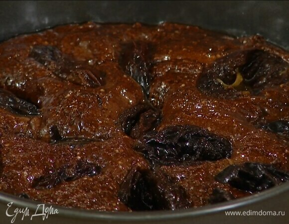 Дно разъемной формы диаметром 22 см выстелить бумагой для выпечки, выложить шоколадное тесто и разровнять его, сверху разложить чернослив.