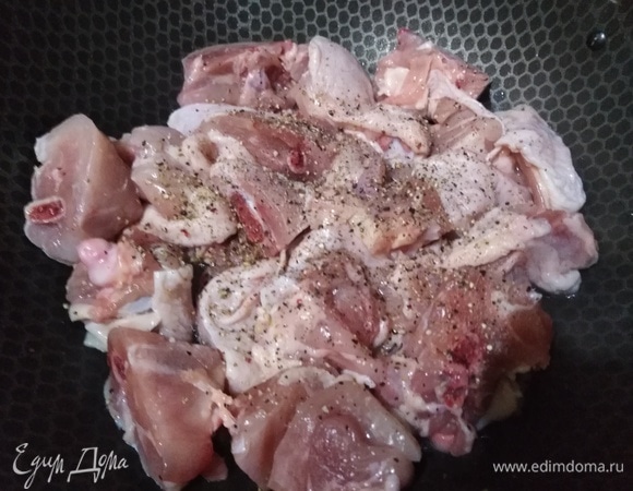 Бедра порубить на куски. Выложить в разогретый с растительным маслом казан. Посолить, добавить перец. Обжаривать в течение 5 минут на сильном огне.