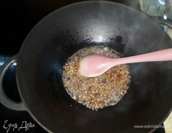 В чугунном казане (сковорода, кастрюля) разогреть подсолнечное масло. В масло всыпать сахар и дождаться, когда он закарамелизируется, то есть станет коричневым. Добавить все сухие специи, прогреть. Зиру я беру в зернышках и измельчаю ее в ступке, так получается ароматнее. Добавить 5 зубчиков чеснока, пропущенных через пресс, и мелко нарезанный имбирь (2–3 см корня). Обжарить все, помешивая.