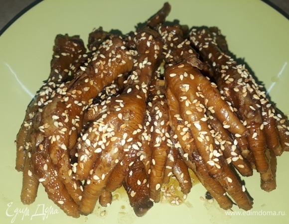 Готовые лапки выложить на блюдо, украсить кунжутными семечками.