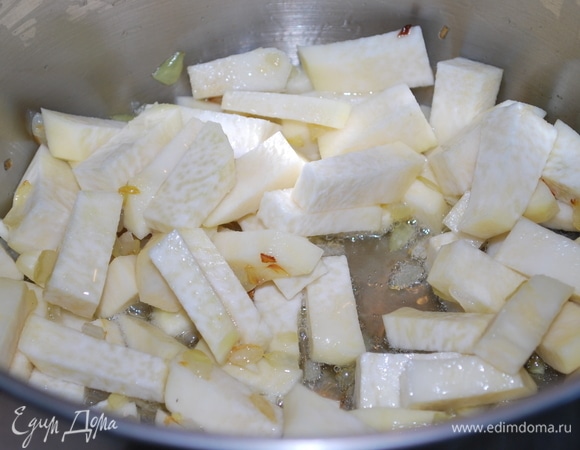 Лук очистите и мелко порубите. В кастрюлю c толстым дном, где будете варить суп, налейте растительное масло и нагрейте на среднем огне. Обжаривайте лук, помешивая, до золотистого цвета. Добавьте кольраби, обжаривайте все вместе.