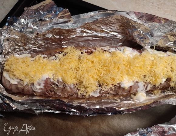 После достать рулет из духовки, раскрыть фольгу. Смазать сметаной и посыпать сыром. Поставить еще на 15 минут запекаться.