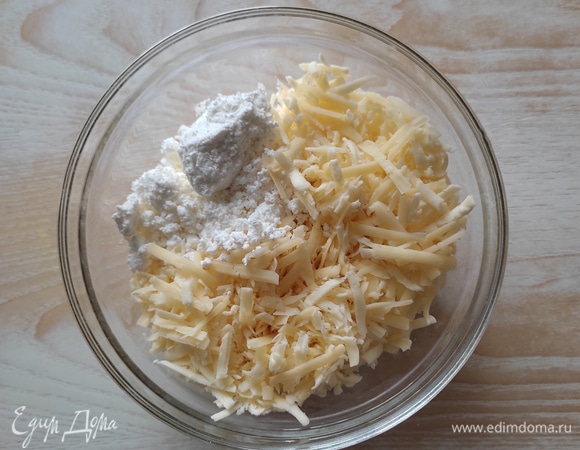 Для начинки натереть на крупной терке оба вида сыра, добавить творог. Яйцо взбить вилочкой и добавить в начинку половину, вторую половину оставить для смазывания конвертиков. Хорошо перемешать начинку.