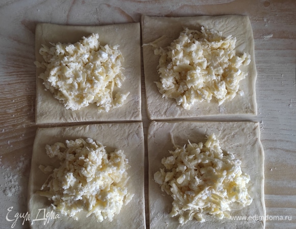 Пласт разрезать на 4 части, выложить начинку на середину каждого квадратика.