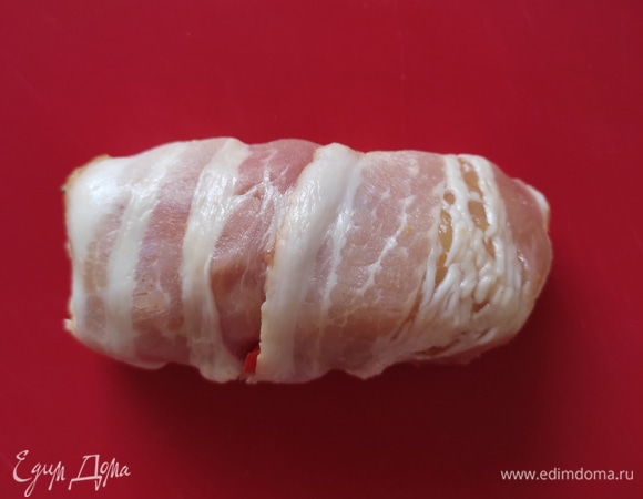 Обернуть рулетик полоской бекона.