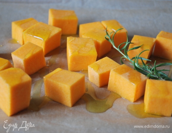 Тыкву очистите и нарежьте средними кубиками. Положите на противень, полейте оливковым маслом, добавьте веточку розмарина.