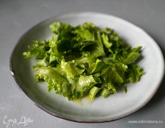 Для заправки смешайте оливковое масло с лимонным соком и медом. Листья салата нарвите руками и смешайте с заправкой, выложите в тарелку.