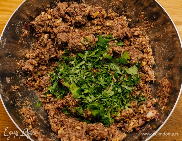Затем — мелко нарезанную кинзу, обжаренные лук и чеснок, хмели-сунели. Посолить, поперчить по вкусу. Перемешать.