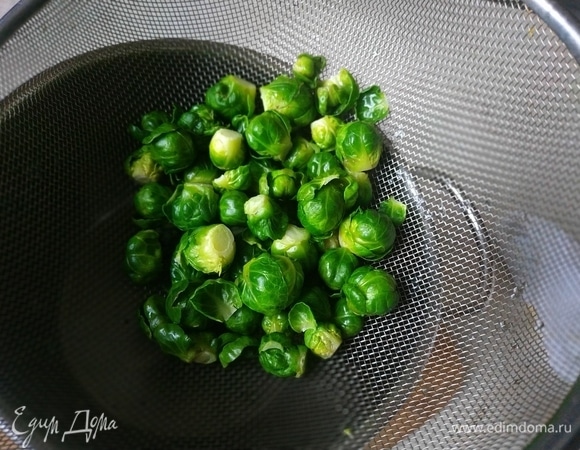 Брюссельскую капусту отварите в кипящей подсоленной воде в течение 1 минуты, откиньте на дуршлаг, чтобы стекла вода.
