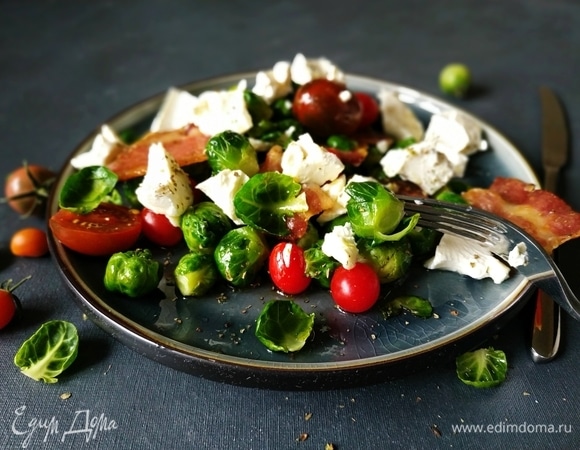 Помидоры черри разрежьте пополам, если они крупные. Сыр поломайте руками, полейте салат заправкой, посыпьте орегано, посолите по вкусу. Подавайте к столу, приятного аппетита.