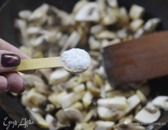 В сковороде разогрейте масло, добавьте грибы, посолите — так грибы быстрее выделят жидкость.