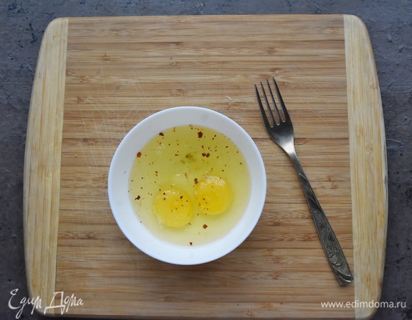 Два яйца размешиваю вилочкой в миске. Солю, добавляю щепотку хлопьев красного острого перца.