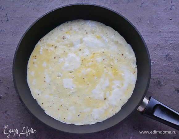 Сковороду разогреваю, смазываю небольшим количеством растительного масла. Вливаю яичную смесь и с помощью ложки распределяю по сковороде с диаметром, не превышающим диаметр тортильи.