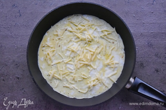 Сверху на яйца выкладываю половину натертого на терке сыра.