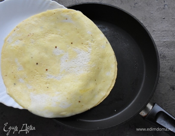 Перемещаю из тарелки обратно в сковороду лепешку в том же положении: тортильей вниз, омлетом наверх.