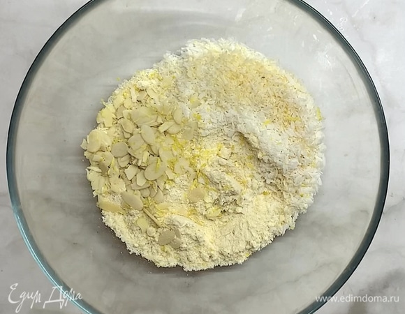 Смешиваем миндальную и кокосовую муку, миндальные лепестки (половину) и добавляем лимонную цедру.