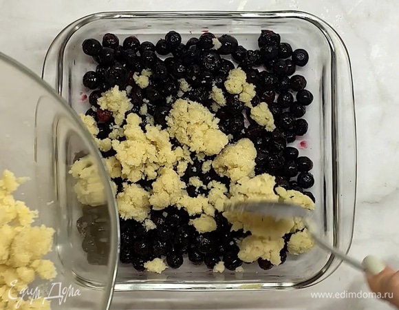 В форму для запекания выкладываем чернику, сверху — тесто. Посыпаем миндальными лепестками.