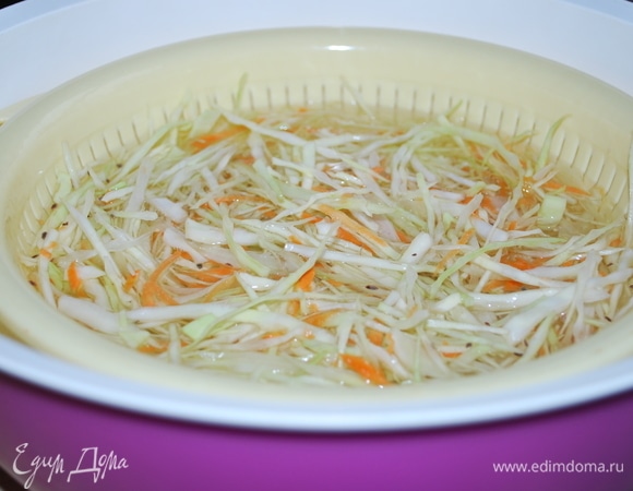 Нашинкованную капусту перемешайте с морковью, мять руками ее не надо, можно добавить по вкусу семена укропа. Партиями опускайте в воду с солью на 9–10 секунд (я использую дуршлаг).