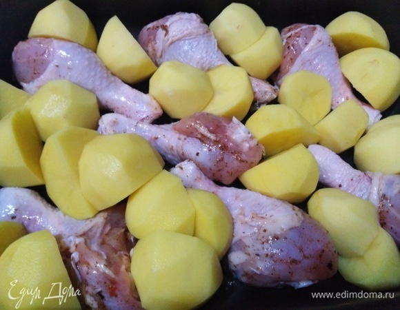 В форму для запекания выложить маринованные ножки, очищенный картофель. Влить маринад.