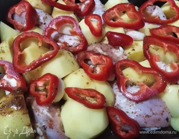 Добавить очищенные зубчики чеснока и нарезанный перец. Накрыть фольгой. Поставить в разогретую до 230°C духовку. Запекать в течение 1 часа.