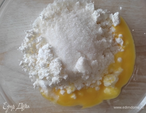 Для творожных шариков к творогу добавляем сахар, желтки и ванилин. Хорошо растираем.