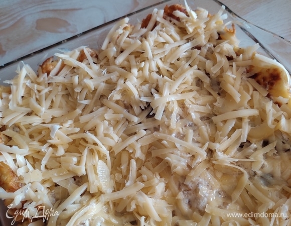 Выложить в форму с кремзликами кусочки мяса, сверху залить луково-сметанным соусом. Сыр натереть на крупной терке и посыпать сверху. Запекать в заранее разогретой до 180°C духовке примерно 15 минут. Подавать, посыпав зеленью. Приятного аппетита!