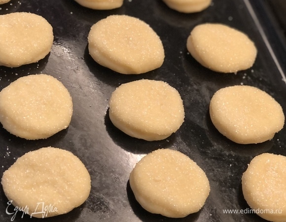 Охлажденное тесто раскатать в пласт толщиной 2–3 мм и формочкой вырезать печенье желаемой формы. Заготовки обмакнуть одной стороной в сахар и выложить на противень на небольшом расстоянии друг от друга. Выпекать в духовке, разогретой до 180°C, около 20 минут (время зависит от духовки и размера печенья). Приятного чаепития!