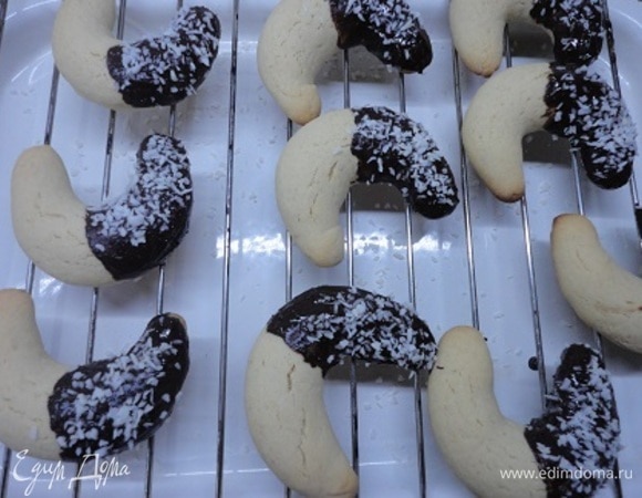 Растопите шоколад на водяной бане, окунайте полумесяцы концами в растопленный шоколад и выкладывайте на решетку. На меня вдруг нахлынуло предновогоднее настроение и я решила припорошить их кокосовой стружкой. Поставьте решетку в холодильник и дайте шоколаду полностью застыть.