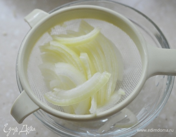 Откиньте лук на сито и дайте стечь лишней жидкости.