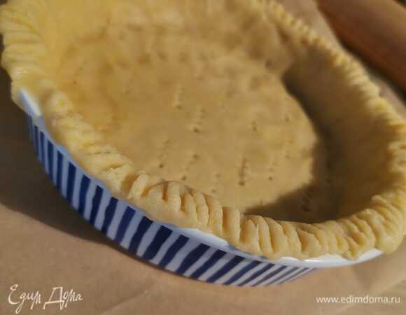 Сначала готовим песочную основу: холодное масло нарезаем на кубики. Смешиваем муку, сахар, соль и масло. Перемешиваем до состояния некрупной крошки. Добавляем яйцо. Важно: так как это песочное тесто, надо сохранять температуру, чтобы не нагревать сильно в руках, так что сильно не вымешиваем. Заворачиваем в пищевую пленку полученную массу и на 30 минут убираем в морозилку. Форму немного смазываем сливочным маслом и посыпаем мукой. Когда пройдет время, раскатываем тесто и выкладываем в форму, формируем бортики. Тесто накалываем вилкой и опять ставим в морозилку на 10 минут. Основу предварительно без начинки выпекаем 15 минут при 180°C.
