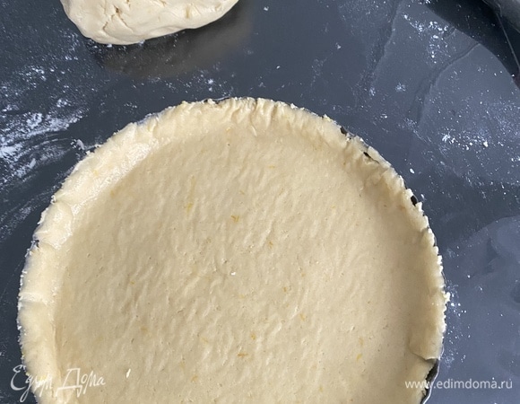 Добавить к яичной массе сухую и быстро замесить однородное тесто. Готовое тесто мягкое, к рукам не липнет. Завернуть тесто в пленку, убрать в холодильник минимум на час. С лимонов снять полностью всю кожуру, произвольно нарезать, удалить косточки. Измельчить в блендере и протереть через сито. Добавить крахмал, сахар и перемешать. Затем между двумя слоями пергамента раскатать большую часть теста в пласт толщиной примерно 5 мм и диаметром больше формы на 3 см.