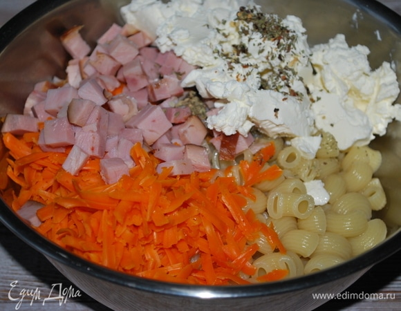 В большую миску выложите макароны, сыр, фету и бекон. Добавьте орегано, соль и свежемолотый черный перец по вкусу. Все хорошо перемешайте.