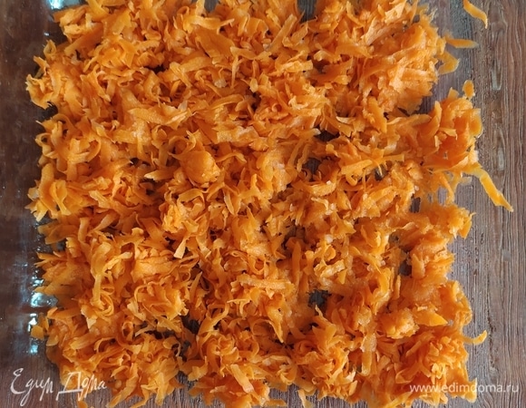 2 средних моркови вымыть, очистить, натереть на крупной терке и выложить на дно формы для запекания.
