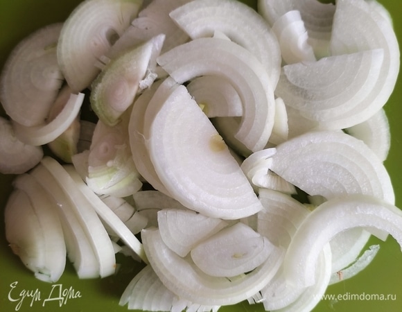 Лук нарезать полукольцами и выложить на рыбу.
