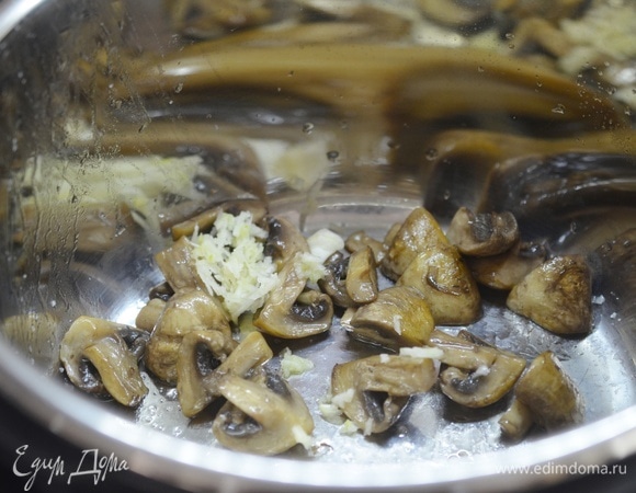 В готовые грибы добавьте измельченный чеснок.