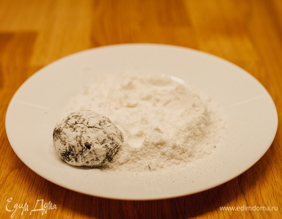 В тарелку просеять сахарную пудру. Покатать шарик, покрыв его сахарной пудрой со всех сторон.
