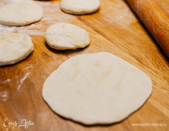 Готовое тесто разделить. На сколько частей, зависит от количества и размера сосисок, у меня получилось 15. Каждый шарик теста раскатать в слегка вытянутый круг.